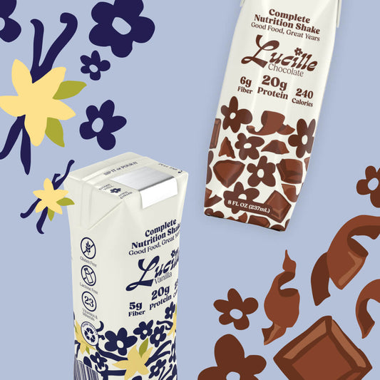 Two Lucille Chocolate nutrition shake cartons on a floral and chocolate background