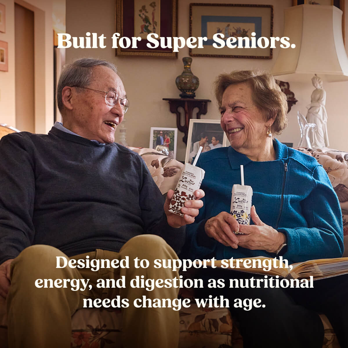Two super seniors sitting together holding drinks with the text "Built for Super Seniors – Designed to support strength, energy, and digestion as nutritional needs change with age."